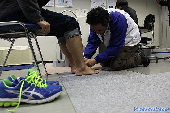 亚瑟士工作人员为跑手测量脚部数据